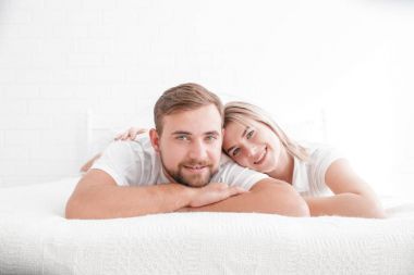 Şehvetli genç çift yatakta birlikte. Beyaz bir arka plan üzerinde izole yatak odasında mutlu çift.