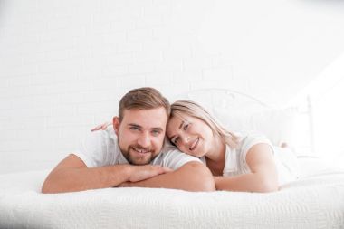 Şehvetli genç çift yatakta birlikte. Beyaz bir arka plan üzerinde izole yatak odasında mutlu çift.