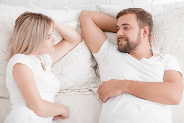 Чуттєва молода пара разом у ліжку. Щаслива пара в спальні ізольована на білому тлі . — стокове фото
