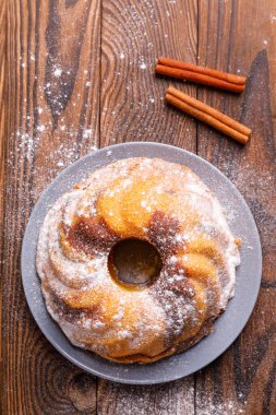 Büyük bir kek tarçın tahta yüzeyi ile.