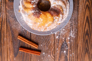 Büyük bir kek tarçın tahta yüzeyi ile.