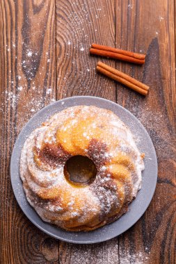 Büyük bir kek tarçın tahta yüzeyi ile.