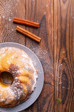 Büyük bir kek tarçın tahta yüzeyi ile.