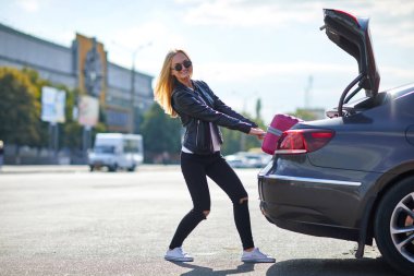 Kız pembe bavulu bagajdan dışarı alır