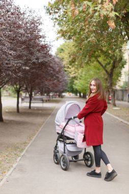 Genç güzel anne ile bebek parkta yürüyüş.