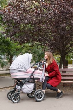 Genç güzel anne ile bebek parkta yürüyüş.