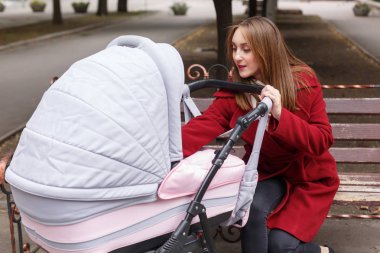 Genç güzel anne ile bebek parkta yürüyüş.