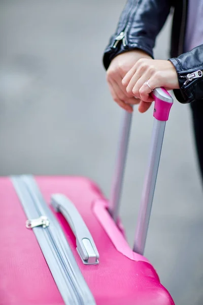 Růžový kufřík detail s dívkou ruku na rukojeť — Stock fotografie