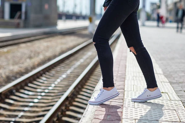 Jambes de fille sur le fond d'un rail de gros plan — Photo