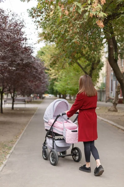 Genç güzel anne ile bebek parkta yürüyüş.