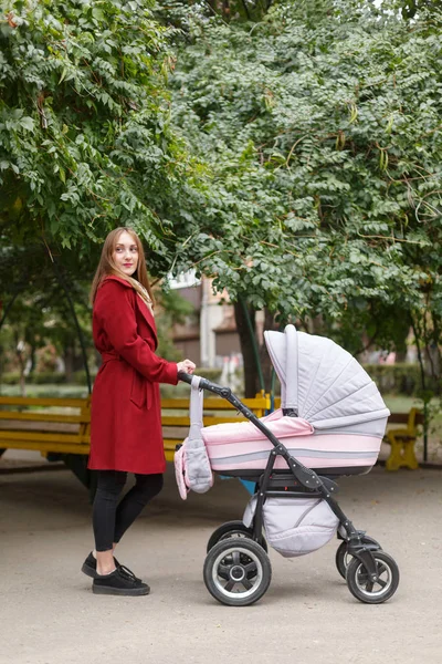 Jovem bela mãe andando com bebê no parque . — Fotografia de Stock