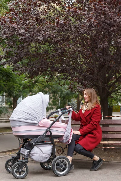 Genç güzel anne ile bebek parkta yürüyüş.