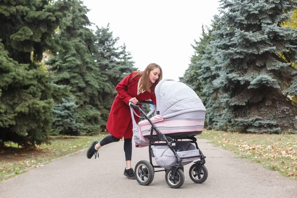 Genç güzel anne ile bebek parkta yürüyüş. — Stok fotoğraf