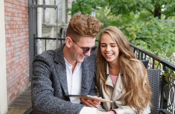 Roztomilý mladý zamilovaný pár s digitálním tabletu na rozostřeného pozadí. Nový koncept technologie. — Stock fotografie