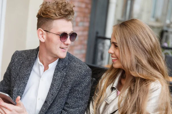 Beautiful romantic couple using a new phone on the blurred background. Internet connection concept. — Stock Photo, Image