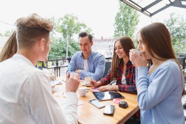 Modern mutlu öğrenciler kafede bulanık bir arka plan üzerinde birlikte çalışma. Aktif yaşam tarzı kavramı.