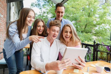 Tablet bir kafe arka plan üzerinde kullanma gençler grup. Mutlu arkadaş tablet ile. Modern yaşam kavramı.