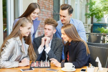 Bir satranç Yarışması bir kafe arka plan üzerinde sahip genç düşünceli arkadaş. Dostluk kavramı.