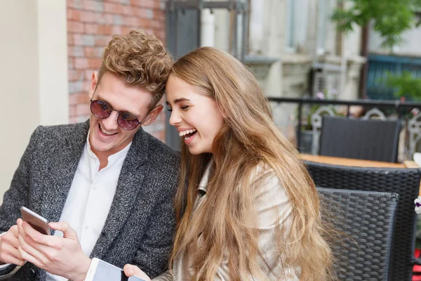 Güzel Romantik Çift bulanık arka plan üzerinde yeni bir telefonu kullanarak. Internet bağlantı kavramı.
