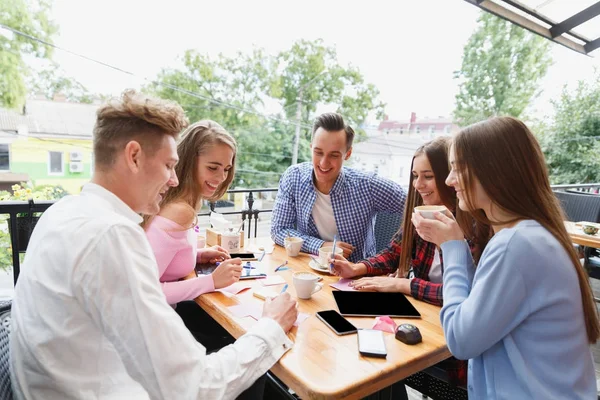 Estudiantes felices modernos trabajando juntos en el café sobre un fondo borroso. Concepto de estilo activo . — Foto de Stock