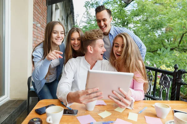 Grupo de adolescentes que utilizan la tableta en un fondo de café. Amigos felices con tableta. Concepto moderno de estilo . — Foto de Stock