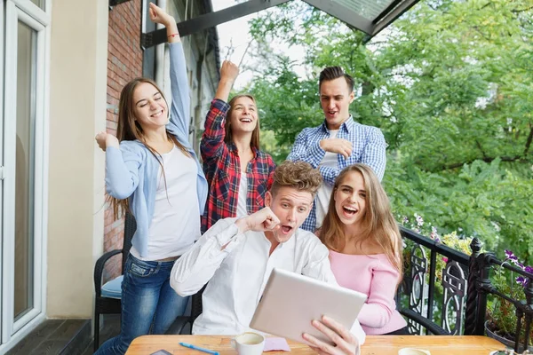 Grupo de adolescentes que utilizan la tableta en un fondo de café. Amigos felices con tableta. Concepto moderno de estilo . — Foto de Stock