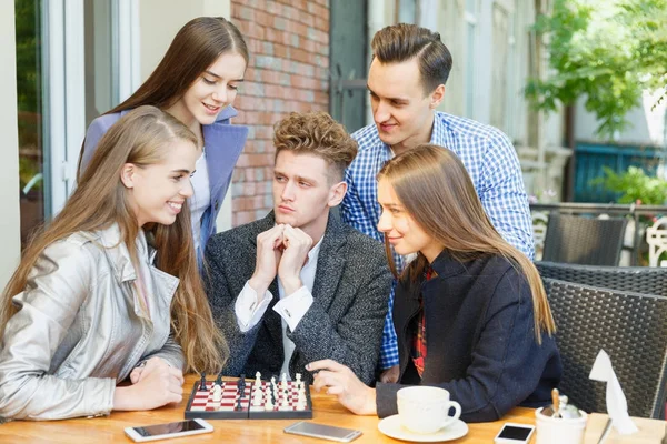 Bir satranç Yarışması bir kafe arka plan üzerinde sahip genç düşünceli arkadaş. Dostluk kavramı.