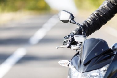 Bir motosiklet bir close-up yalnız sahibi olan yol üzerinde duruyor