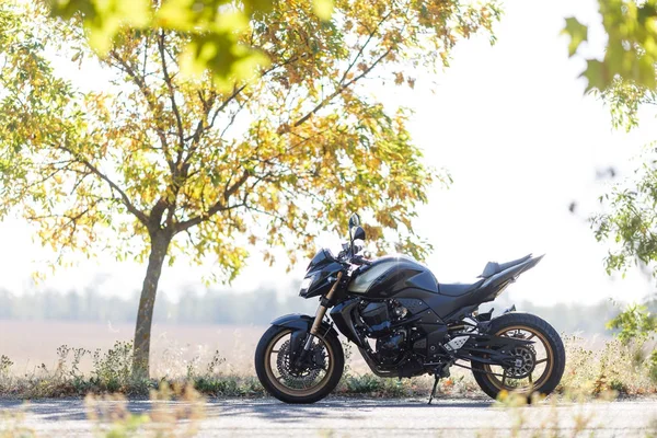 Um close-up motocicleta fica na estrada sozinho — Fotografia de Stock