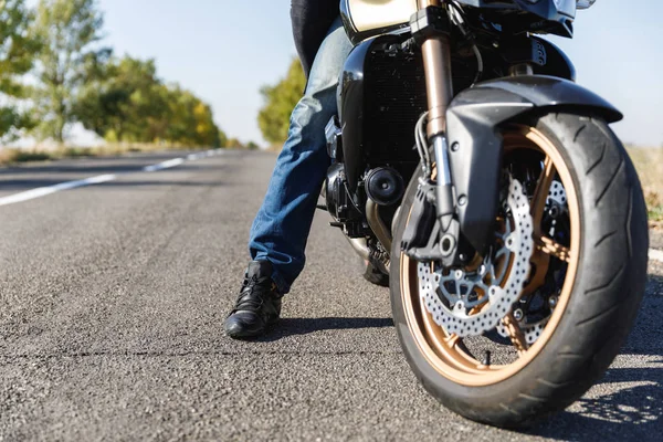 Um close-up de uma motocicleta fica na estrada com seu proprietário sozinho — Fotografia de Stock