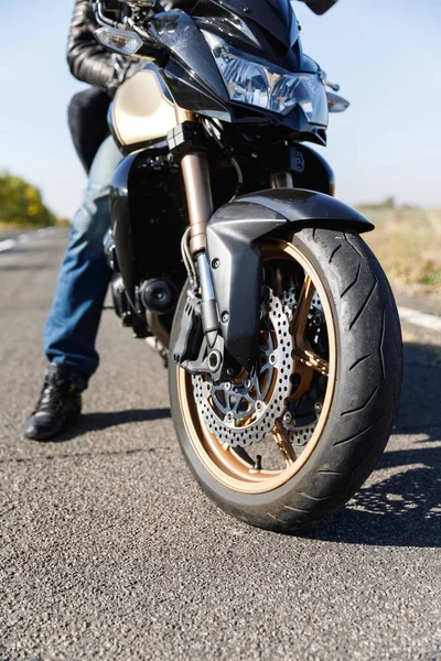 Un primer plano de una motocicleta se encuentra en la carretera con su propietario solo — Foto de Stock