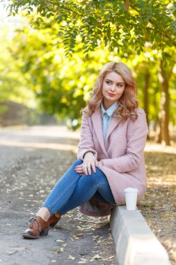 Güzel sarışın Kaldırıma park kahve ile oturuyor.