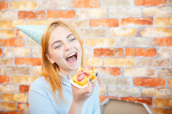 Senhora sorridente do escritório, à hora do almoço e a comer pizza. Ambiente festivo . — Fotografia de Stock