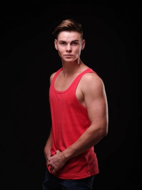 Siyah bir arka plan üzerinde çekici genç adam. Kas dansçı ya da spor adamı. Eğitim kavramı.