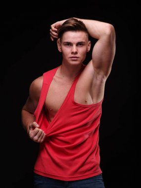 Onun kırmızı t-shirt Siyah bir arka plan üzerine çekerek sağlıklı, güzel, genç adam. Sportif yaşam tarzı kavramı.