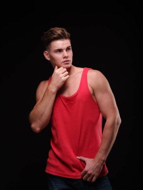 Seksi kaslar üzerinde siyah bir arka plan ile güzel, atletik bir adam. Gençlik güven kavramı.