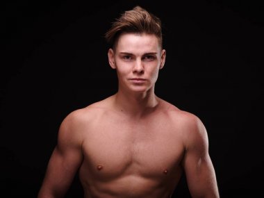 Yakın çekim yakışıklı genç bir siyah arka plan üzerine. Mükemmel erkek modeli. Erkek Cilt Bakımı kavramı.