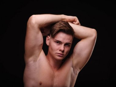 Siyah bir zemin üzerine genç adam seksi, gömleksiz, etkileyici. Kavram eğitimi, egzersiz, spor.