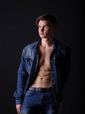 Bir kot ceket siyah bir arka plan üzerinde popüler adam. Seksi şık yakışıklı. Modern moda kavramı.