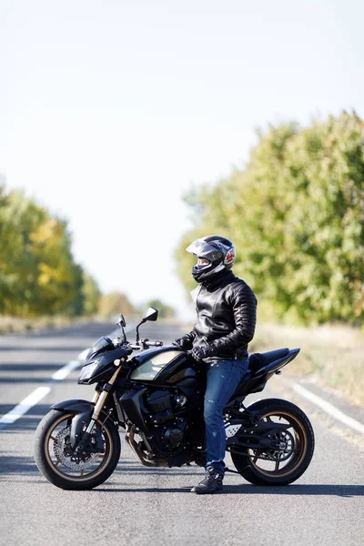 Um close-up de uma motocicleta fica na estrada com seu proprietário sozinho — Fotografia de Stock