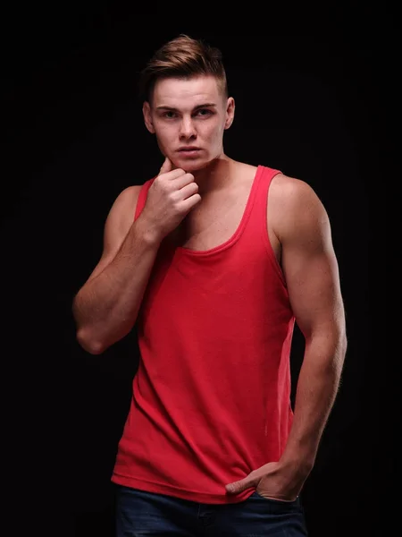 Un tipo guapo sobre un fondo negro. Hombre musculoso apasionado posando. Joven concepto de belleza masculina . — Foto de Stock