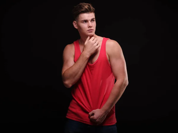 Mooie, sportieve man met sexy spieren op een zwarte achtergrond. Vertrouwen jeugdconcept. — Stockfoto