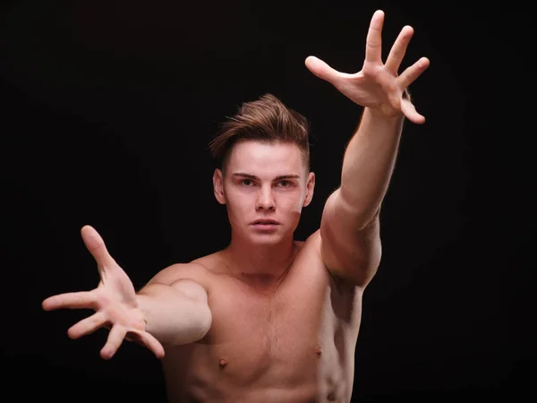 Bonito homem esticando braços fortes sobre um fundo preto. Combate corpo a corpo. Conceito de sparring . — Fotografia de Stock