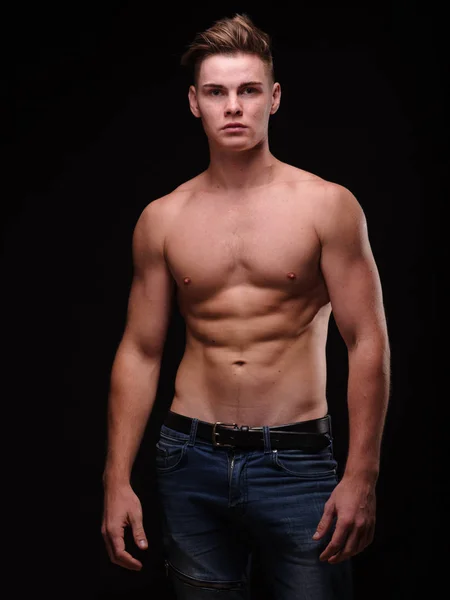 Gezonde tiener jongen shirtless op een zwarte achtergrond. Sportieve jonge mannen. Het concept van de spier gebouw. — Stockfoto