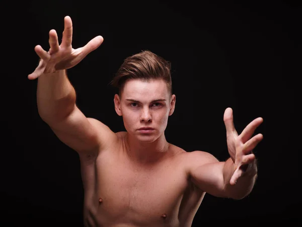 Bonito homem esticando braços fortes sobre um fundo preto. Combate corpo a corpo. Conceito de sparring . — Fotografia de Stock