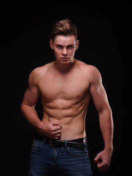 Gezonde tiener jongen shirtless op een zwarte achtergrond. Sportieve jonge mannen. Het concept van de spier gebouw. — Stockfoto