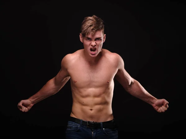 Sexy, shirtless, gillende jonge man op een zwarte achtergrond. Training, opleiding, sport concept. — Stockfoto