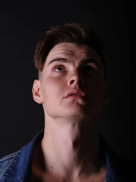 Close-up menino adolescente bonito em um casaco de jeans em um fundo preto. Corte de cabelo masculino e conceito de estilo . — Fotografia de Stock