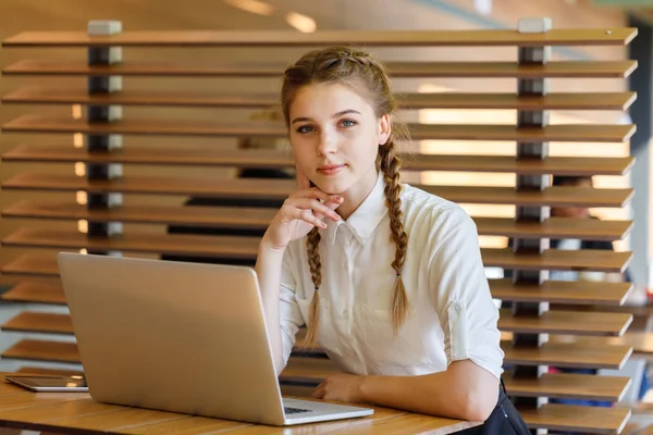 Dizüstü bilgisayarın arkasındaki kız bir caf oturuyor — Stok fotoğraf