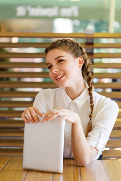 Menina bonita passa tempo com gadgets em um café — Fotografia de Stock